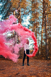 Full length of woman with pink umbrella standing on land