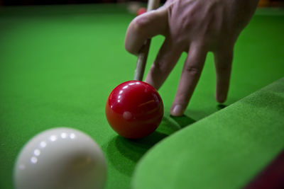 Close-up of hand playing with ball on table