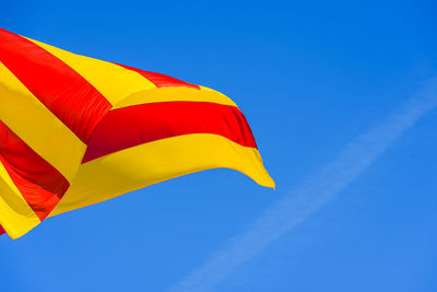 Low angle view of flag against blue sky