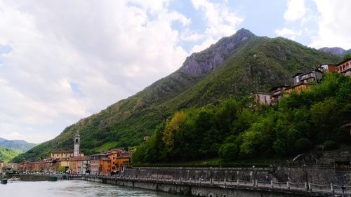 Panoramic view of buildings and mountains against cloudy sky