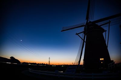 Low angle view of traditional windmill against clear sky at night