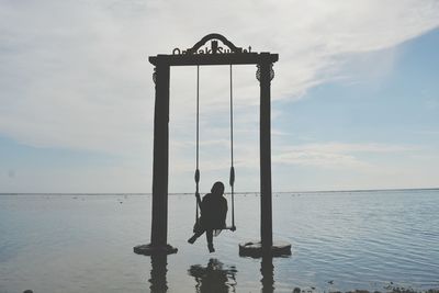 Reflection of man in sea against sky