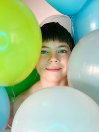 Multi balloons and portrait of young boy 