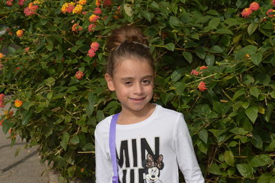 Portrait of smiling girl standing against plants