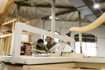 Craftsmen working at table saw in industry