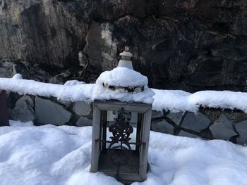 Snow covered lamp and rocks during winter