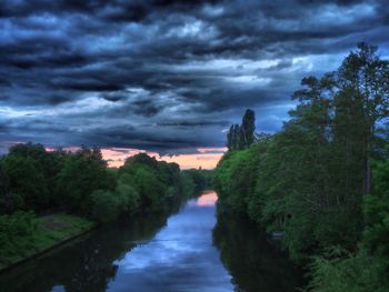 Scenic view of river against cloudy sky