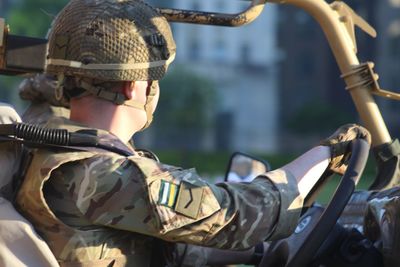 Side view of army soldier sitting in vehicle