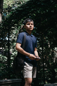 Portrait of man standing against trees