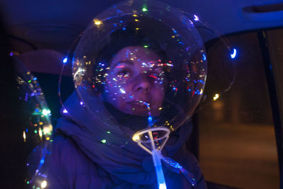 Portrait of woman with illuminated lights at nightclub