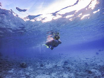 Young women coral reef scuba diving in sea ocean of curacao
