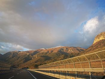 Road leading towards mountains against sky