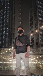 Full length of man standing at illuminated city at night