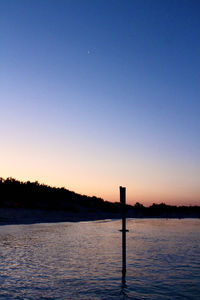 Scenic view of lake against clear sky during sunset