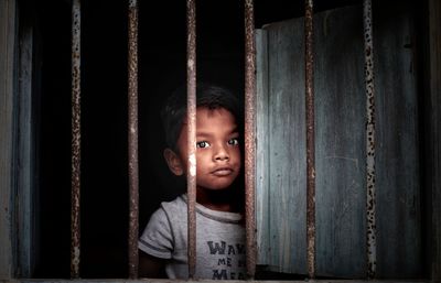 Portrait of cute boy looking through window