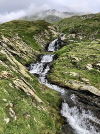 Scenic view of waterfall against sky