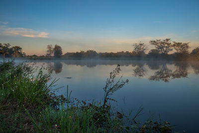 Scenic view of lake against sky during sunset