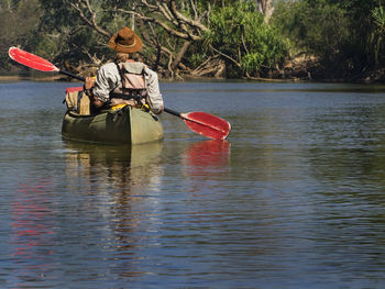 Boat sailing on river by trees