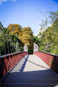 Footpath amidst trees against clear sky