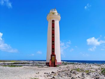 Lighthouse by sea against sky