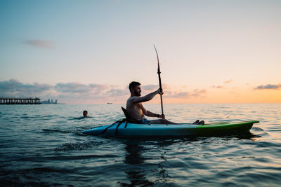 Man kayaking on sea against clear sky