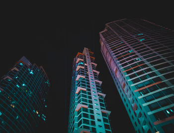 Low angle view of illuminated buildings against sky at night