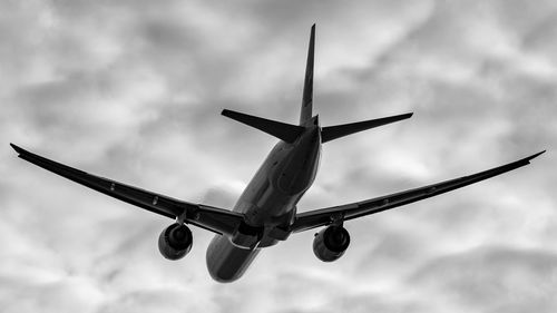 Low angle view of airplane flying against sky