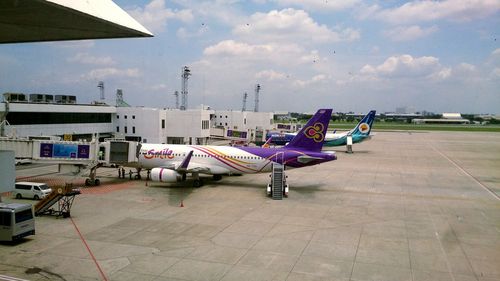 Airplane on airport runway against sky