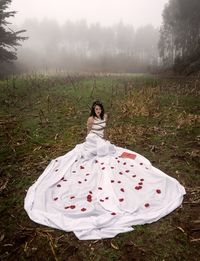 Young woman with umbrella on field