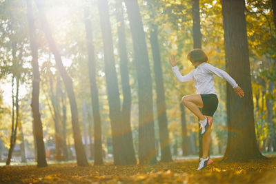 Full length of man jumping in forest