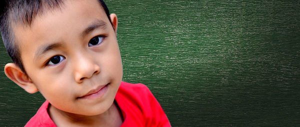 Close-up portrait of cute boy against lake