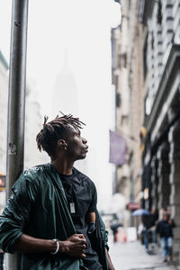 Young man looking at city street