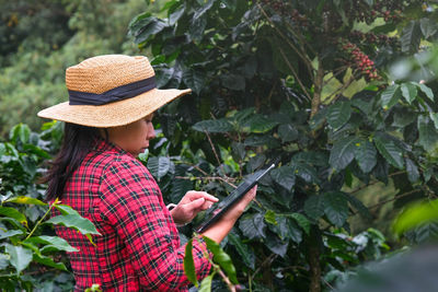 Rear view of woman standing against plants