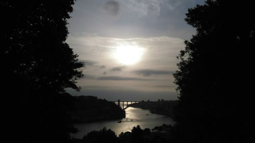 Scenic view of river against cloudy sky at sunset