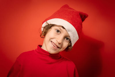 Portrait of smiling young woman against red background