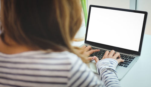 Midsection of woman using laptop on table