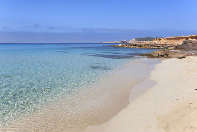 View of calm beach against blue sky