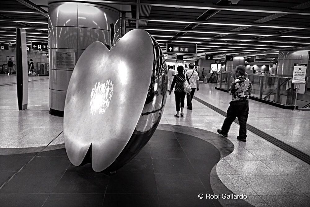 indoors, lifestyles, men, person, architecture, airport, leisure activity, built structure, transportation, standing, public transportation, walking, rear view, modern, travel, incidental people, railroad station, city life, reflection