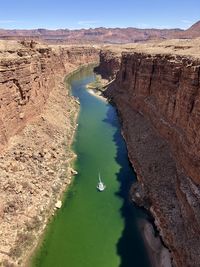 Scenic view of boat on green river in canyon