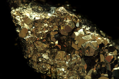 Close-up of illuminated lighting equipment on rock against black background