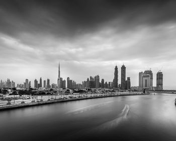 View of buildings in city against cloudy sky