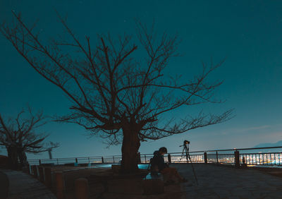 Woman by sea against clear sky