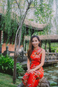 Portrait of young woman sitting at park