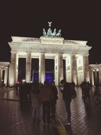 Tourists in front of building at night