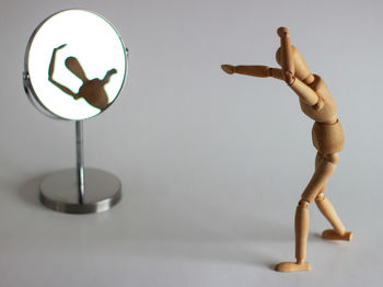 Close-up of figurine on table against wall