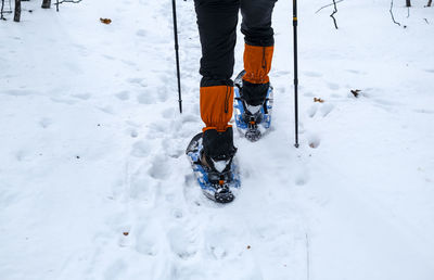 Low section of person on snowcapped field during winter