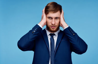 Portrait of young man against blue background