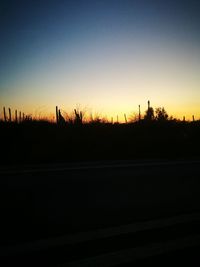 Silhouette landscape against clear sky during sunset