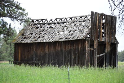 Abandoned barn on field against sky