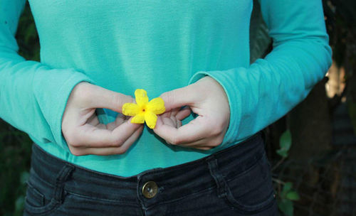Close-up of woman holding yellow flowers